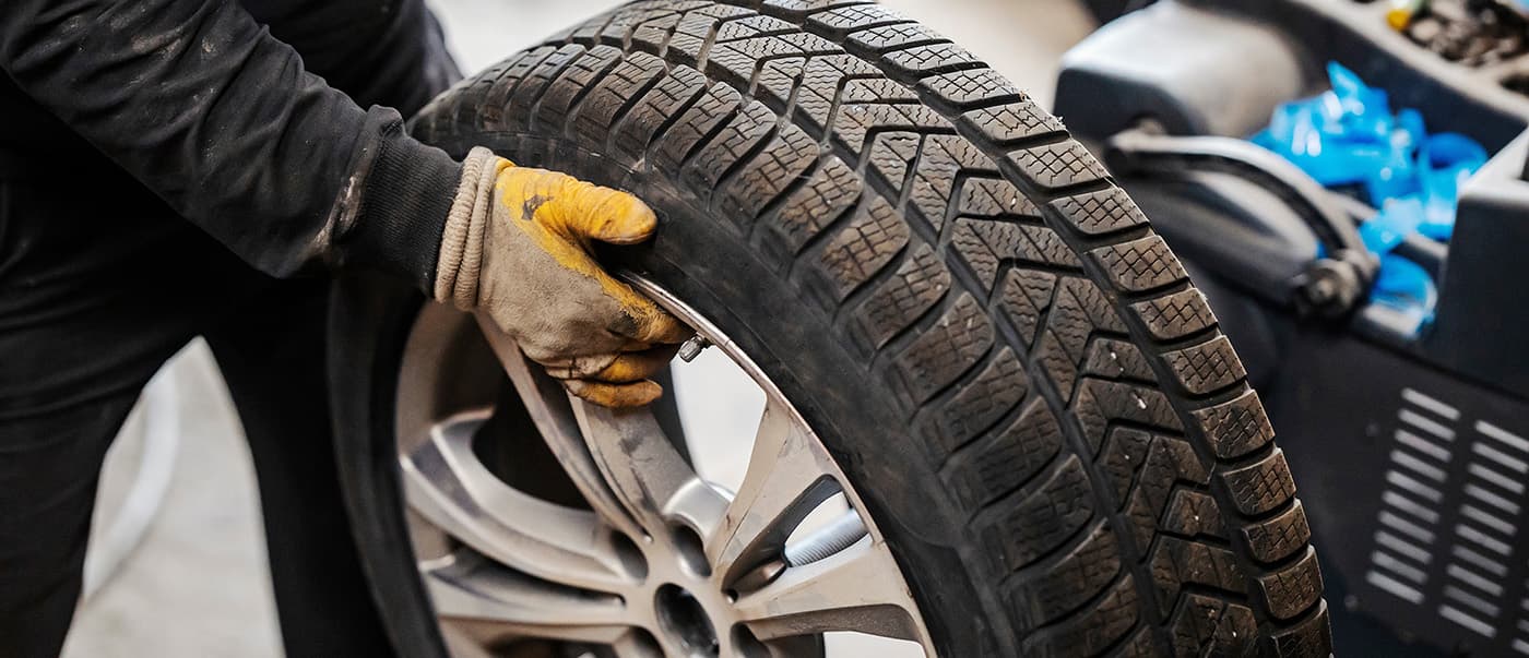 Cropped picture of mechanic holding car wheel Cropped picture of mechanic holding car wheel