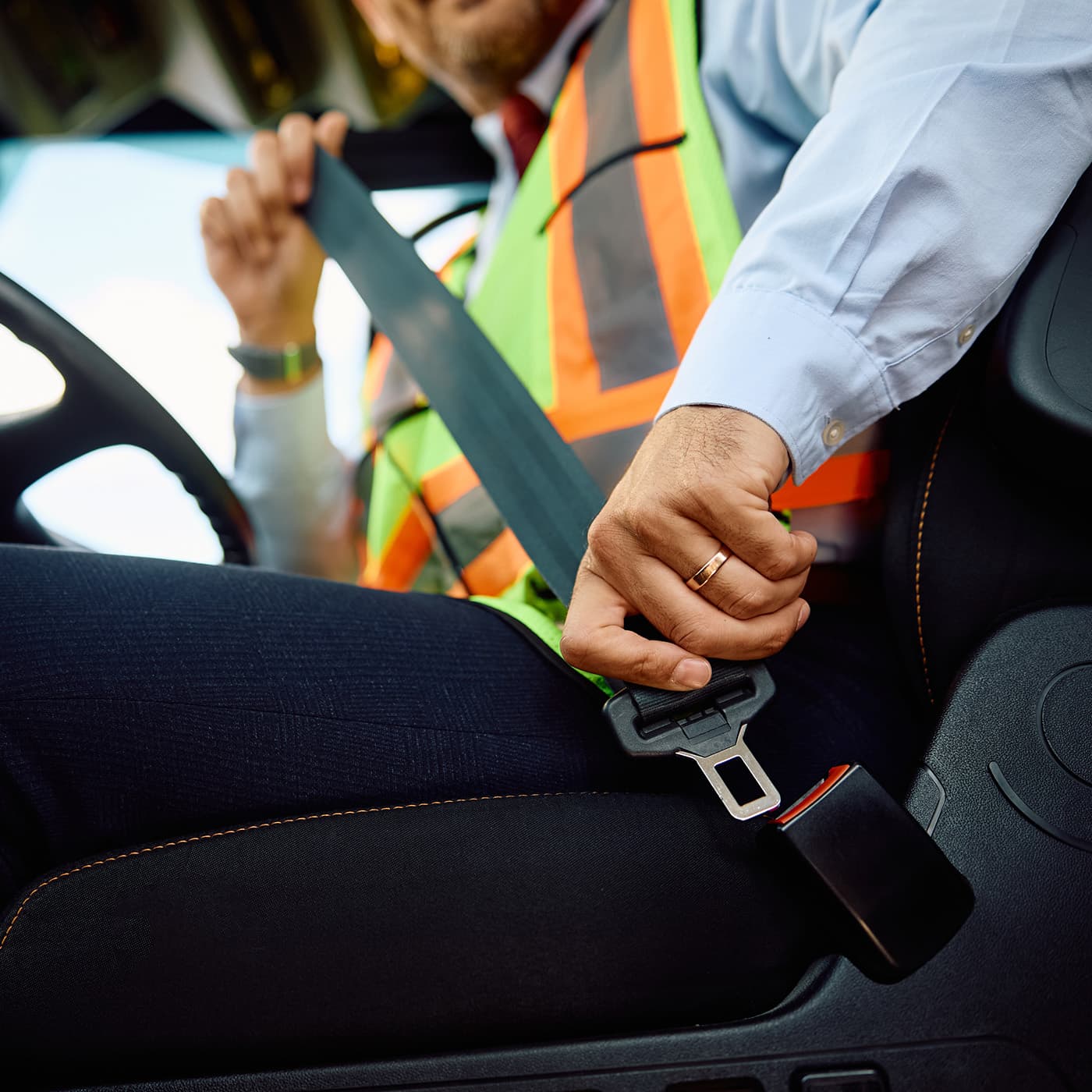 Close up of driver fastening seatbelt while driving a vehicle. Close up of driver fastening seatbelt while driving a vehicle.
