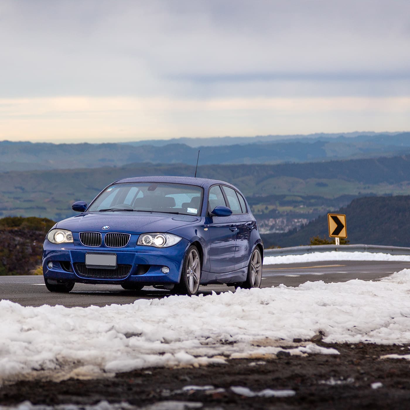 A blue hatchback car on a snowy road in Ohakun, New Zealand. A blue hatchback car on a snowy road in Ohakun, New Zealand.