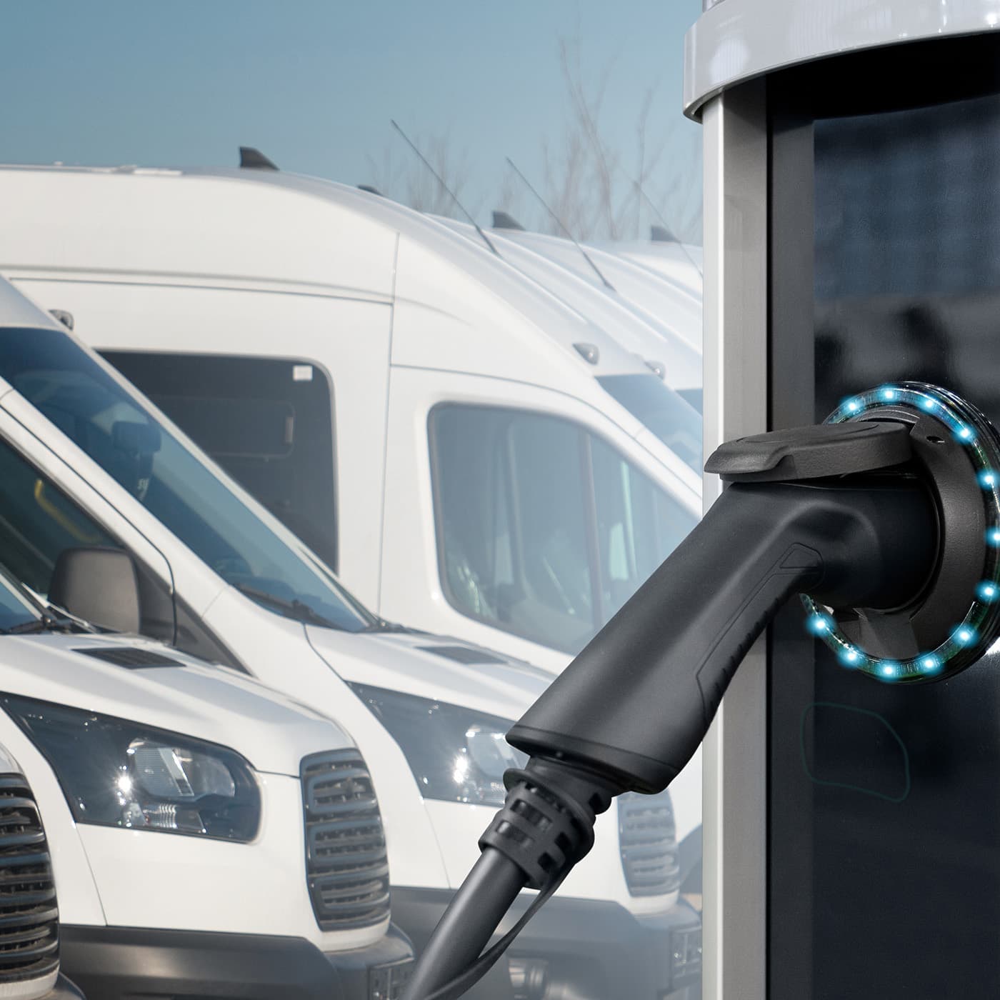 Electric vehicles charging station on a background of a row of vans. Electric vehicles charging station on a background of a row of vans.
