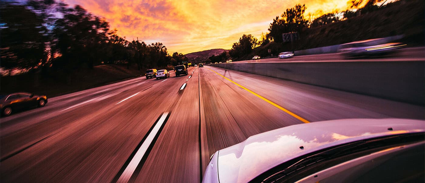 Cars driving on a multiple lane highway at sunset. Cars driving on a multiple lane highway at sunset.