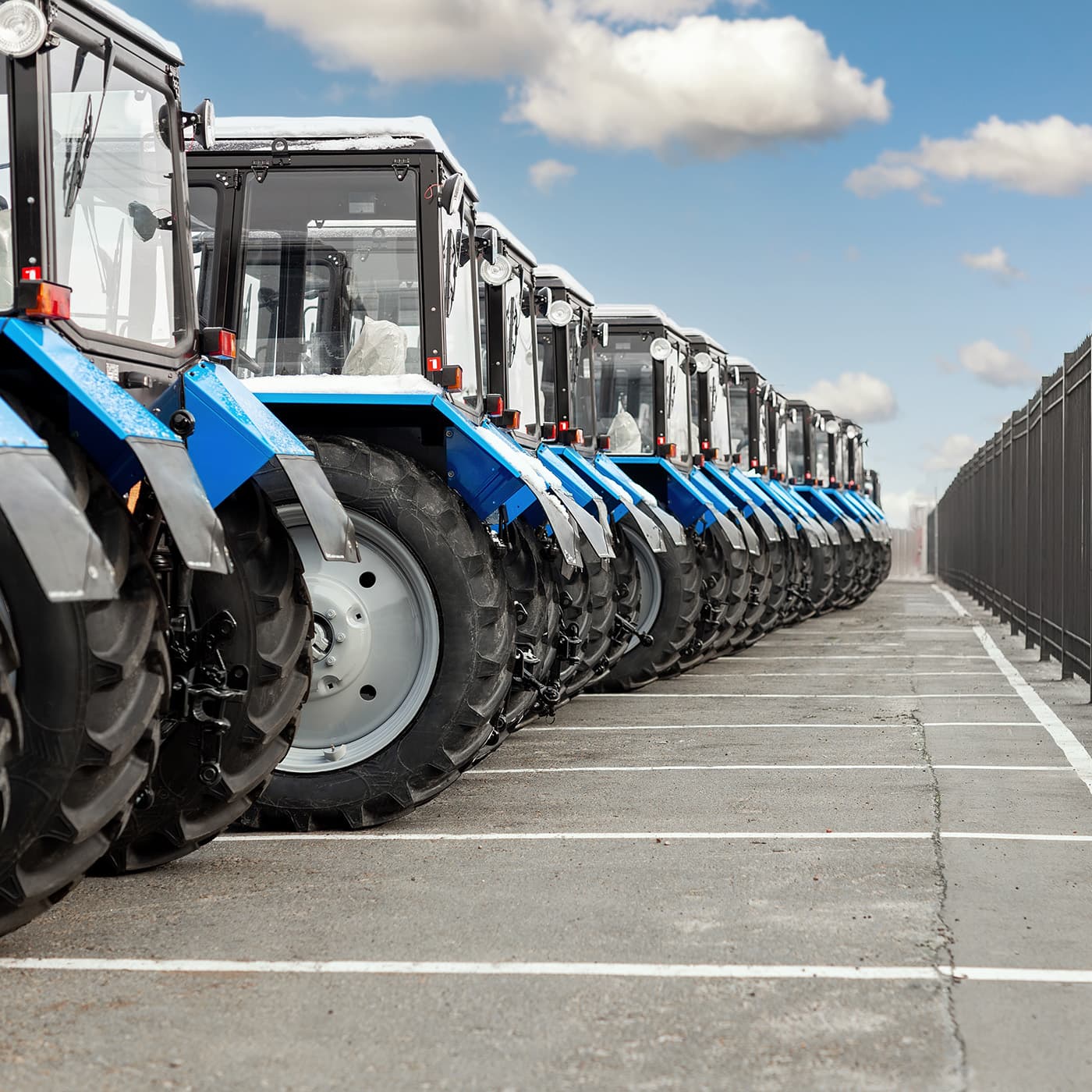A row of tractors parked in a row. A row of tractors parked in a row.