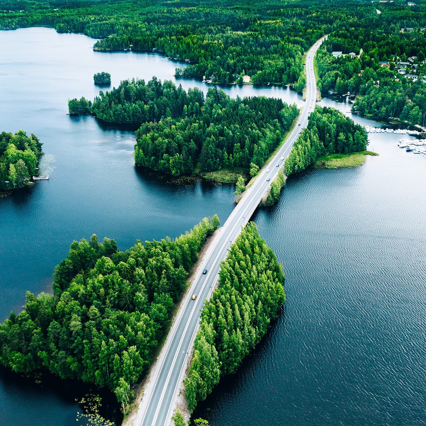Aerial view of bridge asphalt road with cars and blue water lake or sea and green woods. Aerial view of bridge asphalt road with cars and blue water lake or sea and green woods.