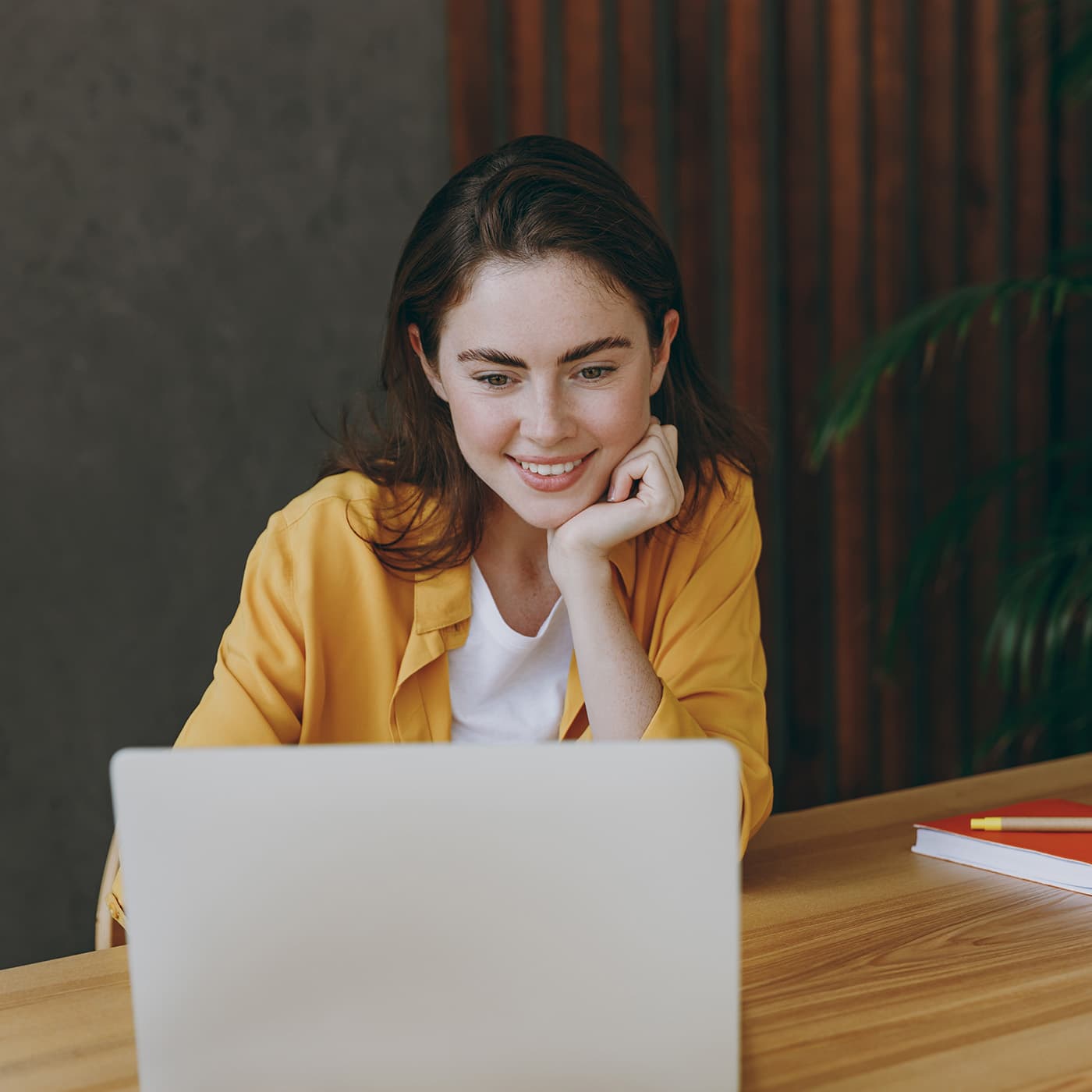 Young business woman wearing casual yellow shirt using a laptop to access Fleet Office. Young business woman wearing casual yellow shirt using a laptop to access Fleet Office.