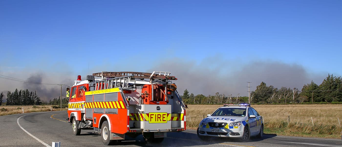 A fire truck and police car attending the scene of a wildfire in New Zealand. A fire truck and police car attending the scene of a wildfire in New Zealand.