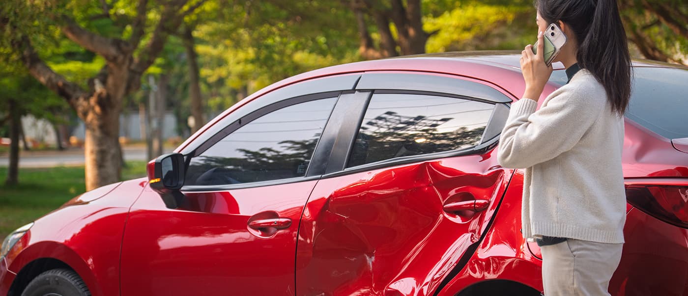 Young woman after a car accident on her phone, calling her insurance company. Young woman after a car accident on her phone, calling her insurance company.