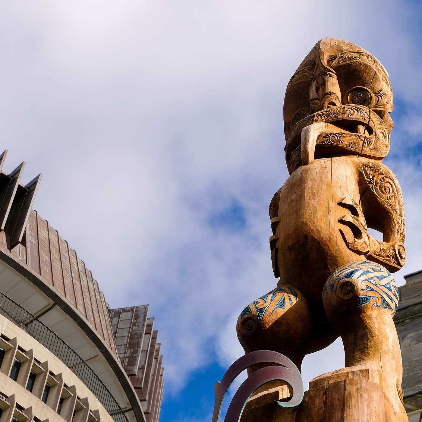 Close up of Maori Te Kāhui Mōuri the clan of vitality carved pou overlooking the Beehive parliament buildings in the capital city of NZ Aotearoa. Close up of Maori Te Kāhui Mōuri the clan of vitality carved pou overlooking the Beehive parliament buildings in the capital city of NZ Aotearoa.